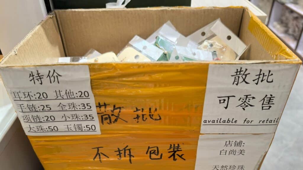 Open box with jewelry items and price list.