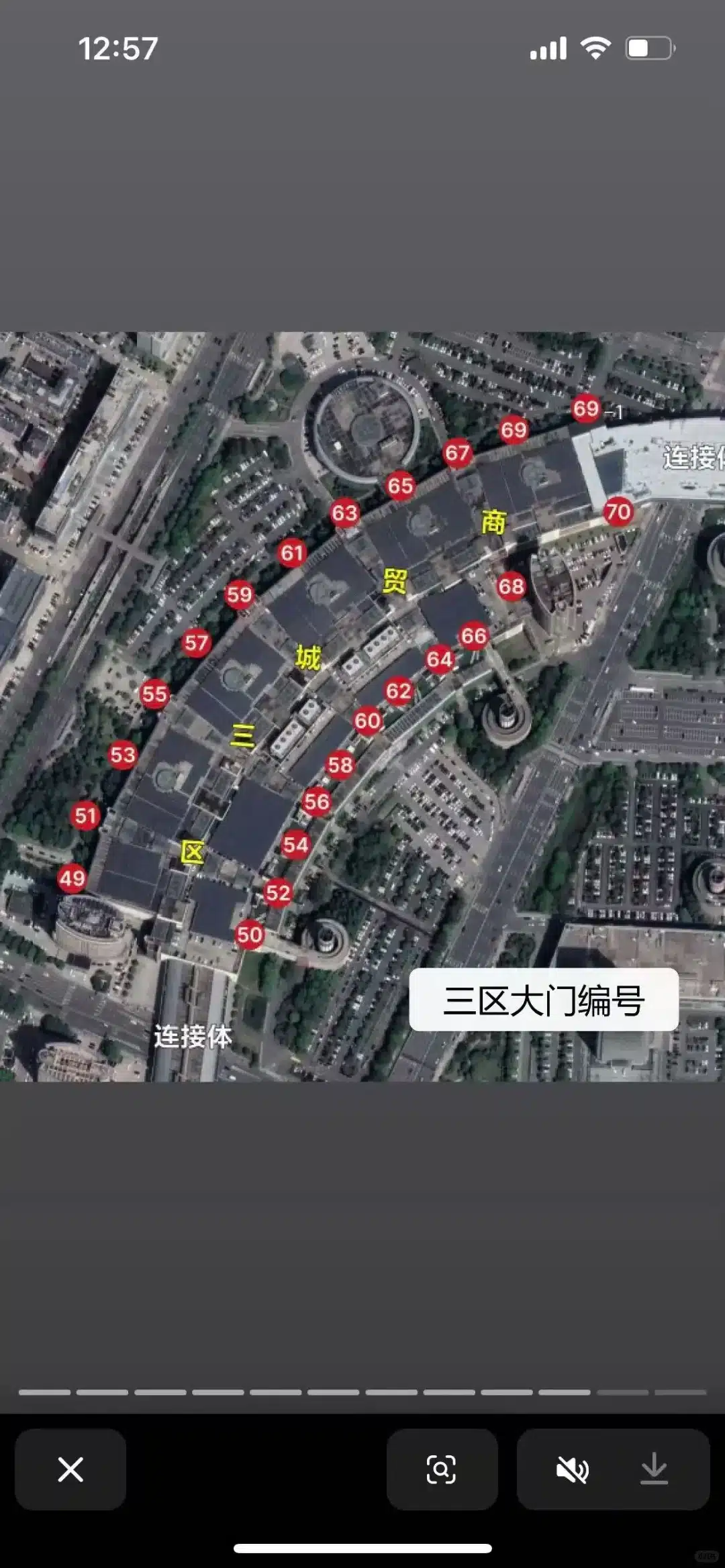 Aerial satellite view displaying a complex with numbered markers and labels in red circles, indicative of an urban area layout.