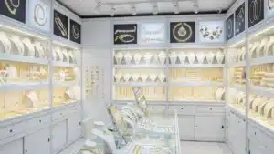 Interior of a jewelry store with white cabinets showcasing gold necklaces, bracelets, and earrings neatly arranged and displayed.