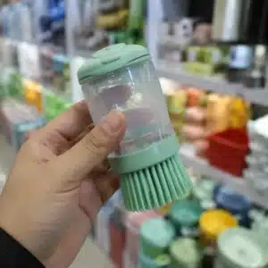 Hyper-realistic product photography, close-up of an Amazon seller's hand holding a plastic kitchen gadget at a Yiwu booth, background blurred with shelves of colorful household items, sharp focus on product texture and stitching, soft overhead lighting, inviting and trustworthy atmosphere, no text, no brand logo, shot on Canon EOS R5, 50mm, f/2.8, natural light