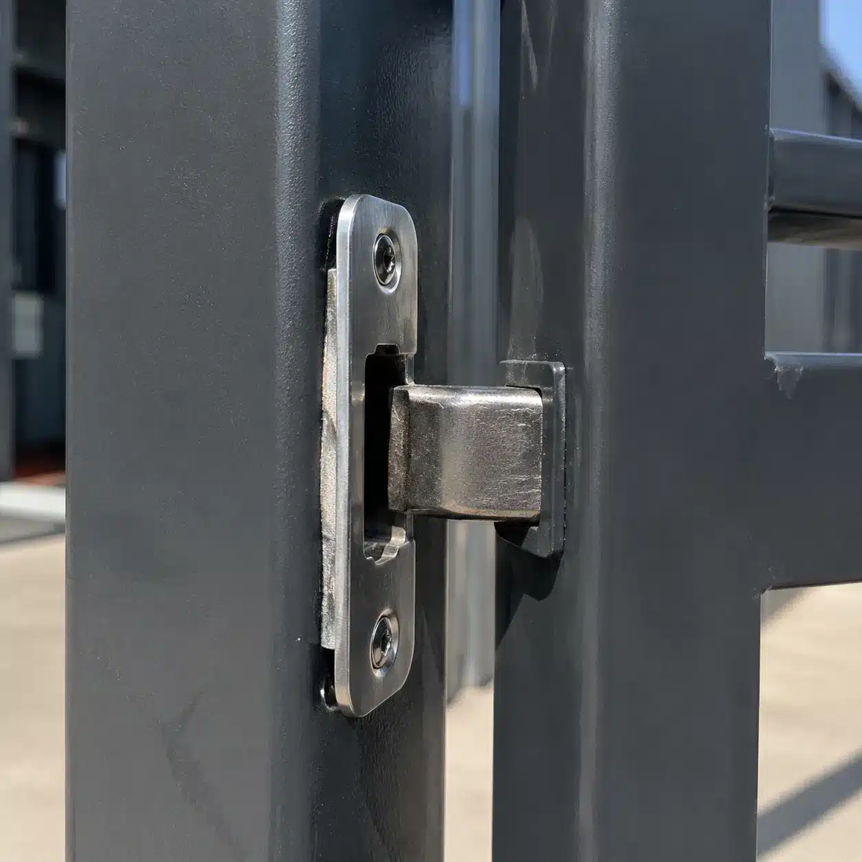 Gate latch strike plate sitting misaligned by roughly one millimetre against the latch bolt