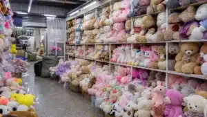 Rows of plush teddy bears and soft animal toys stacked in a Chinese wholesale market booth